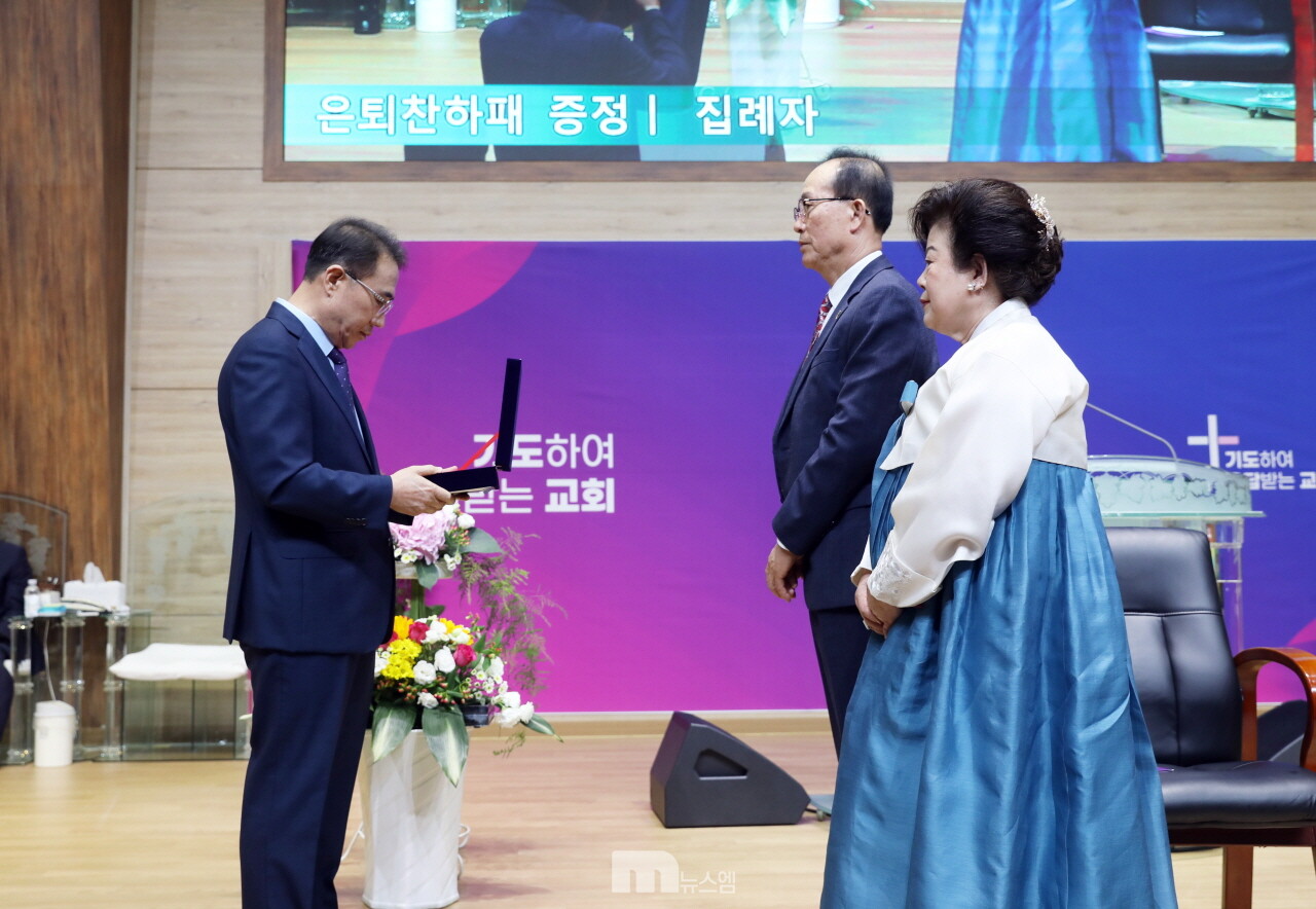 노인호 목사가 권오태 장로에게 은퇴찬하패 전달 모습