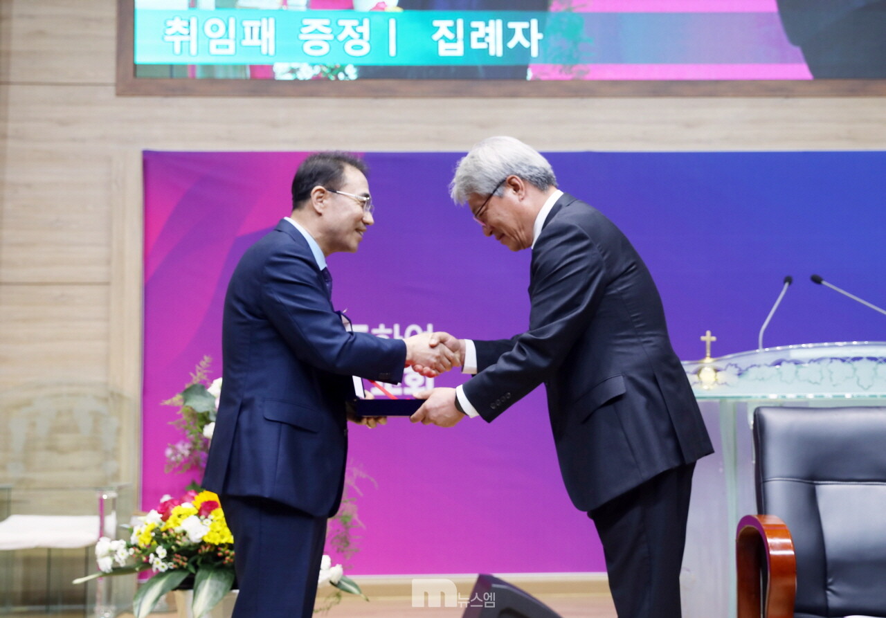 노이호 목사가 김종국 장로에게 취임패를 전달하는 모습